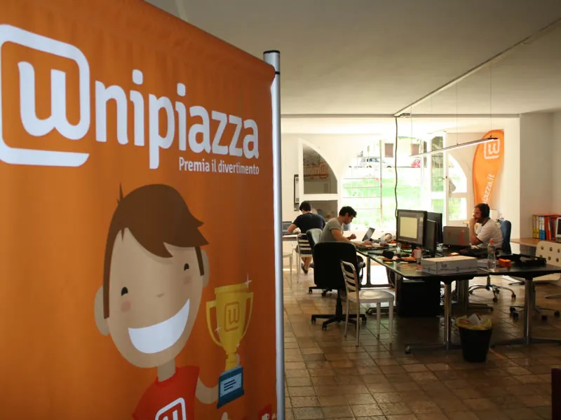 Il primo ufficio di Unipiazza a Padova, con il roll-up arancione «Premia il divertimento»
