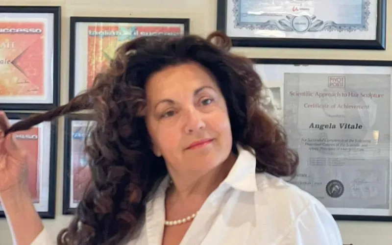 Angela Vitale nel suo salone Lunghezza Vitale, davanti agli attestati