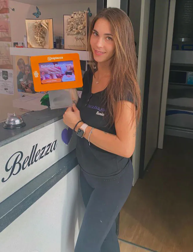 Un’operatrice di Estetica Beautique accanto al Chiosco Unipiazza