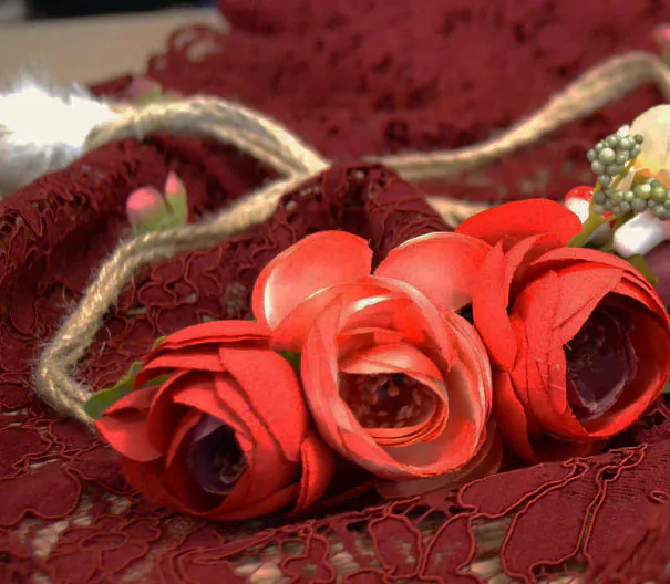 Rose di stoffa rosse su un pizzo