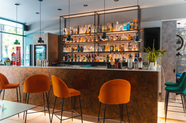 Il bancone del bar con gli sgabelli arancioni